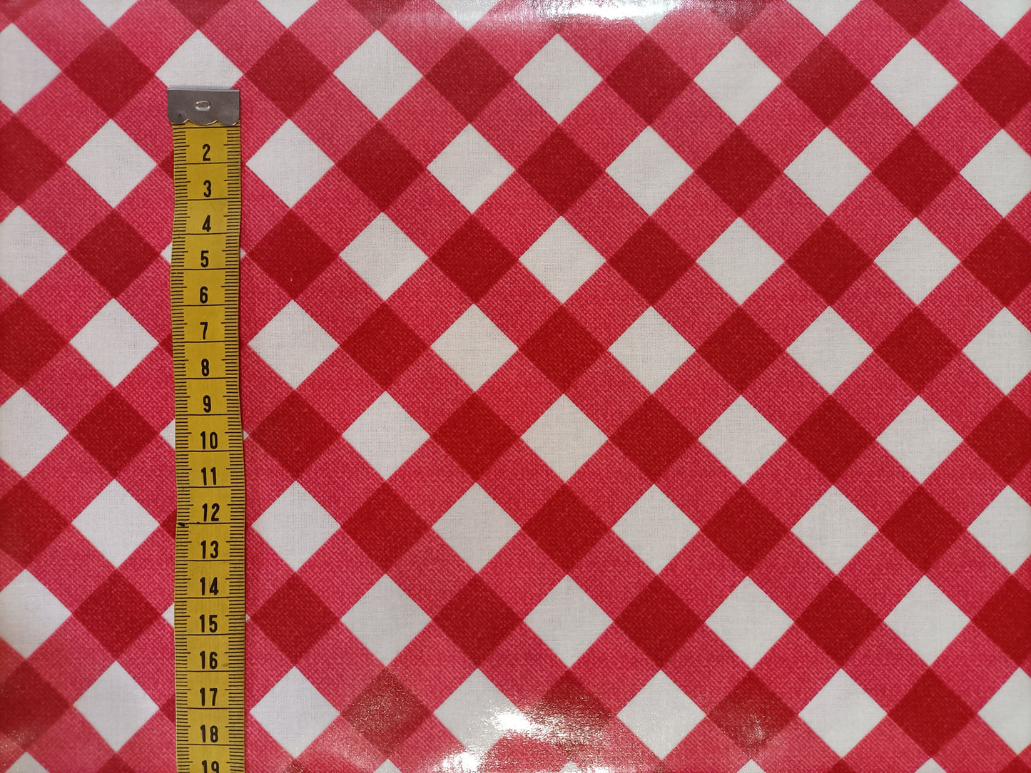 Red and white check laminated cotton with ruler to show pattern size